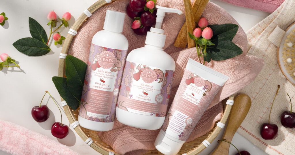 Scentsy body wash, hand cream, and hand soap displayed with fresh flowers and cherries